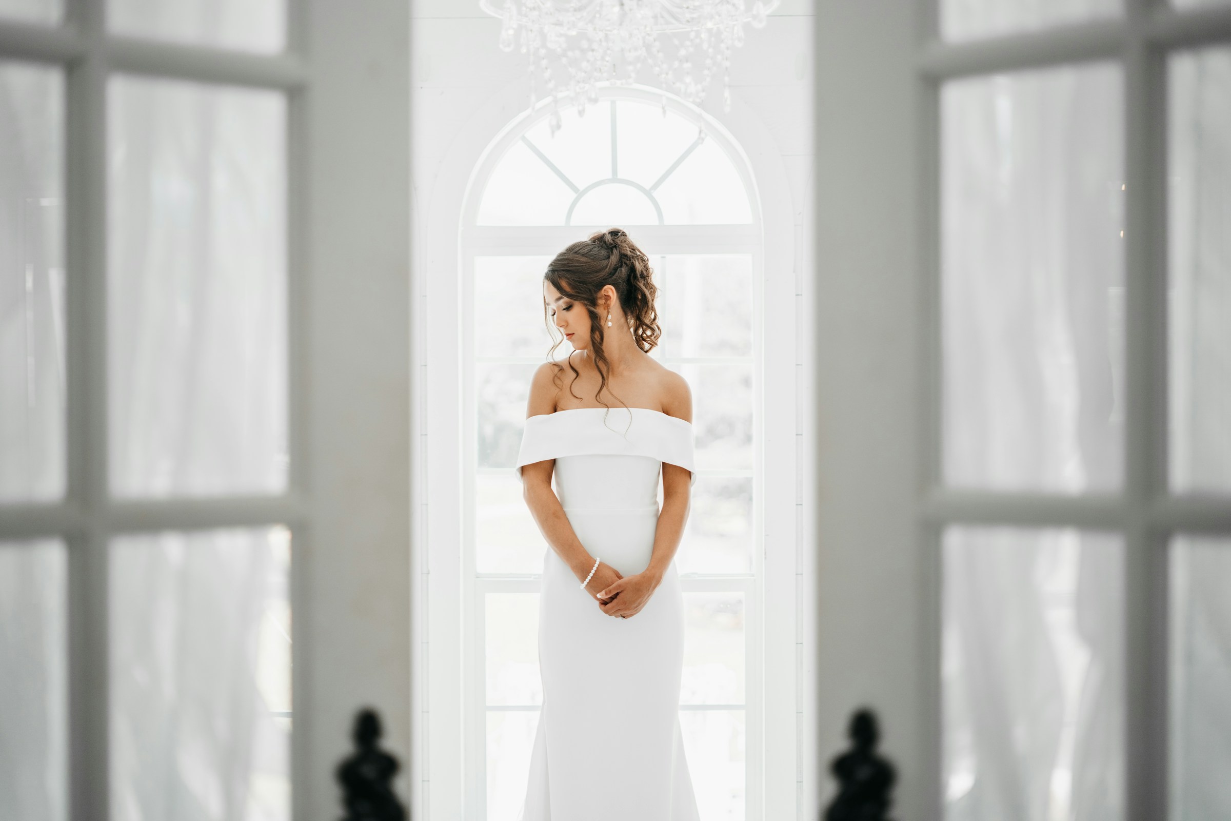 Bride with elegant bridal updo in a bright arched-window setting